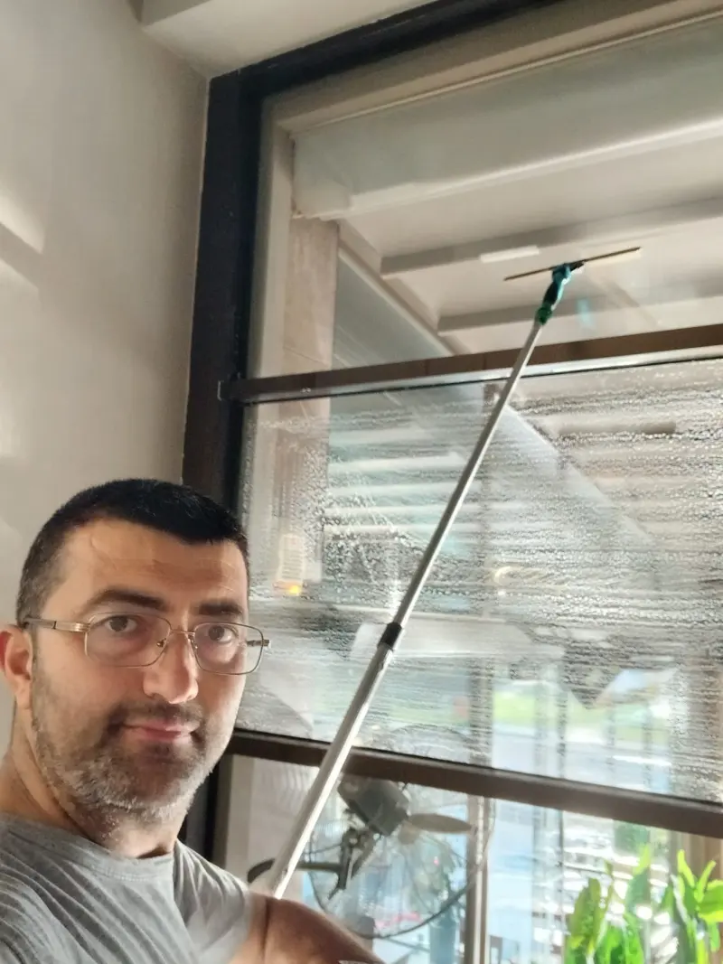ACT Profesyonel Cam Temizleme ustası pencere silecek ile çalışırken